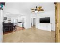 Open-concept living area featuring tile flooring, ceiling fan, and seamless flow into kitchen at 3310 W Ballast Point Blvd, Tampa, FL 33611