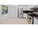 Modern kitchen with stainless steel appliances and white cabinetry at 3447 Killdeer Pl, Palm Harbor, FL 34685