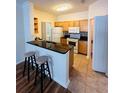 Bright kitchen featuring granite counters, wooden cabinets, breakfast bar, and modern appliances at 4207 S Dale Mabry Hwy # 9106, Tampa, FL 33611