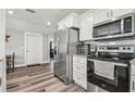 Modern kitchen featuring stainless steel appliances, white cabinets, and hardwood floors at 4802 18Th St, Zephyrhills, FL 33542