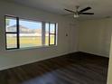 Bright living room featuring dark wood-look floors, a ceiling fan, and a large window showcasing the exterior at 502 Johnson Rd, Plant City, FL 33566