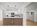 Modern kitchen features white cabinets, stainless steel appliances, black hardware, and a stylish backsplash at 5405 S Sellas St, Tampa, FL 33611