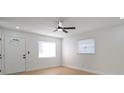 Bright living room with new floors, a ceiling fan, and a front door with decorative glass at 5405 S Sellas St, Tampa, FL 33611