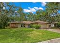 Charming single-story home with well-maintained lawn, two-car garage and mature trees at 56 Bay Woods Dr, Safety Harbor, FL 34695