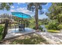 Inviting dock with seating area under a bright blue umbrella, perfect for waterfront enjoyment at 7300 Mackerel Ln, Hudson, FL 34667