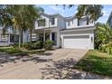 Charming two-story home featuring a well-manicured lawn, bright blue front door, and a two-car garage at 7309 S Shamrock Rd, Tampa, FL 33616