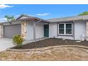 View of a single-story home featuring a well-maintained lawn, stone accents, and a covered entryway at 8010 Chickasaw Ln, Port Richey, FL 34668