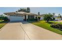 Charming single Gathering home with a well-maintained lawn and a spacious two-car garage at 913 El Rancho Dr, Sun City Center, FL 33573
