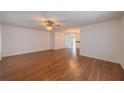 Spacious living room with hardwood floors, ceiling fan, and views of the dining area at 913 El Rancho Dr, Sun City Center, FL 33573