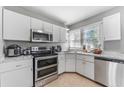 Bright kitchen with white cabinets, stainless steel appliances, tile flooring, and a large window at 918 E 24Th Ave, Tampa, FL 33605