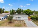 Beautifully maintained home with a well manicured lawn, front entrance, and driveway, captured from an aerial perspective at 9241 Cochise Ln, Port Richey, FL 34668