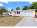 A lovely single story home with a light colored exterior, garage, driveway and landscaped front yard at 9241 Cochise Ln, Port Richey, FL 34668