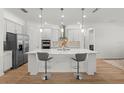 Modern kitchen with a large island, barstool seating, and stainless-steel appliances at 9271 Rally Spring Loop, Wesley Chapel, FL 33545