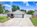 Beautiful single-story home with a two-car garage, manicured lawn, and white perimeter fence at 1017 Cameo Crest Ln, Valrico, FL 33596