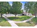 Landscaped front yard features mature trees, a well-maintained lawn, and a white picket fence at 1017 Cameo Crest Ln, Valrico, FL 33596