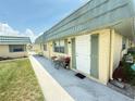 Inviting condo entrance with seating area and well-maintained landscaping at 102 Cambridge Trl # 230, Sun City Center, FL 33573