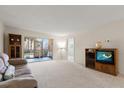 Bright living room with a sliding glass door to a screened-in lanai at 11485 Oakhurst Rd # 200-101, Largo, FL 33774