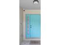 Close-up of the bright blue front door with sidelight and welcome mat at 11845 Autumn Creek Dr, Riverview, FL 33569