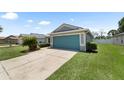 Home with a blue garage door, manicured lawn, and a clean, well-maintained exterior at 11845 Autumn Creek Dr, Riverview, FL 33569