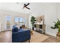 Bright living room featuring a blue sofa, wood floors, natural light, a ceiling fan and stylish decor at 121 E Warren Ave # 4, Tampa, FL 33602