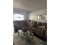 Cozy living room with recliner sofas, stylish decor, neutral rug, and bright natural light at 1220 57Th N St # 103C, St Petersburg, FL 33710