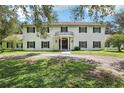 Classic two-story home featuring a stately entrance with a balcony and symmetrical design at 12433 Kelso Rd, Thonotosassa, FL 33592