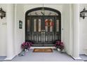 Up close look at the front door with decorative glass and sidelights, flowers, and a 'Hello' mat at 12433 Kelso Rd, Thonotosassa, FL 33592