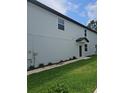 Side view of a home featuring light blue siding and a well-maintained lawn at 19643 Shady Oak Dr, Land O Lakes, FL 34638
