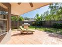 Tiled back patio with a chaise lounge and a grill for outdoor entertaining at 2024 Glen Forge St, Brandon, FL 33511