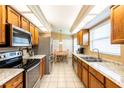 Bright kitchen featuring wooden cabinetry, stainless steel appliances, and tile flooring at 2024 Glen Forge St, Brandon, FL 33511