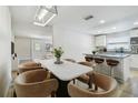 Open-concept dining area adjacent to the kitchen, featuring barstool seating and modern light fixture at 205 W 122Nd Ave, Tampa, FL 33612