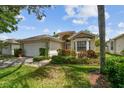 Charming one-story home with a two-car garage, lush landscaping, bay window, and covered entryway at 2216 Evans Rd, Clearwater, FL 33763