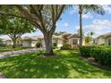 Charming one-story home with a two-car garage, driveway, mature trees, lush landscaping and covered entryway at 2216 Evans Rd, Clearwater, FL 33763
