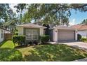 Charming single-story home featuring a well-manicured lawn and a two-car garage at 2617 Heatherwood Dr, Tampa, FL 33618