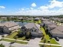 Aerial view of the home, lake and neighborhood, showcasing the home's landscaping, large lot and proximity to the water at 33255 Kateland Dr, Wesley Chapel, FL 33545