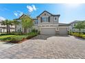 Beautiful two-story home boasting a three-car garage, paver driveway, lush landscaping, and a neutral color scheme at 33255 Kateland Dr, Wesley Chapel, FL 33545