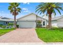 Charming single-Gathering home with a two-car garage, paved driveway, and lush lawn at 4012 Marine Pkwy, New Port Richey, FL 34652