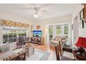 Cozy living room with a bay window, ceiling fan, and comfortable seating, perfect for relaxation at 404 Laurel Lake Dr # 101, Venice, FL 34292