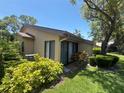 Exterior view of the home with lush greenery and a beautiful tree in the backyard at 4558 Morningside # 43, Sarasota, FL 34235
