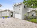 Beautiful gray two-story home featuring a white garage door and fenced-in front yard at 464 20Th Ave, Indian Rocks Beach, FL 33785