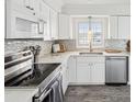 Well-lit kitchen featuring stainless steel appliances, white cabinetry, and tiled backsplash at 464 20Th Ave, Indian Rocks Beach, FL 33785