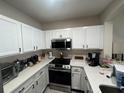 Well-lit kitchen with ample cabinet space, stainless steel microwave and quartz countertops at 527 Glenn Cross Dr, Ruskin, FL 33570