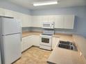 Bright kitchen featuring white appliances and tile flooring at 5303 Terraza Ct, Temple Terrace, FL 33617