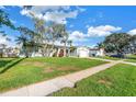 Beautiful house, featuring an expansive green lawn, mature trees, a driveway and sidewalks in a lovely neighborhood at 5925 18Th Ne St, St Petersburg, FL 33703