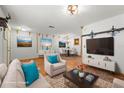 Spacious staged living room with modern decor open to the dining area at 7703 N Branch Ave, Tampa, FL 33604