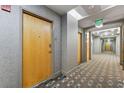 Condo hallway with an exit sign and carpet with geometric pattern leading to apartments at 777 N Ashley Dr # 1506, Tampa, FL 33602