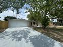 Charming one-story home featuring an attached garage and spacious front yard at 7831 Fox Hollow Dr, Port Richey, FL 34668