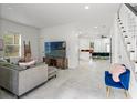 Bright living room with tile flooring and staircase leading to upper level at 7911 N Packwood Ave, Tampa, FL 33604