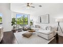 Cozy living room with a large window, dark floors, plush white sectional, and modern decor at 820 2Nd N Ave, St Petersburg, FL 33701