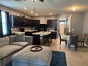 Open-concept kitchen and living area showcasing modern black cabinetry, ample seating, and natural light at 821 Lucent Sands Ct, Brandon, FL 33511